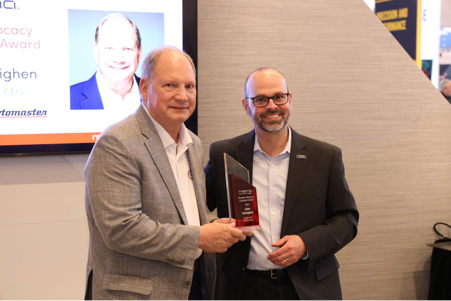 John Hanighen of Cloyes photographed recieving a red plaque from Paul McCarthy of MEMA